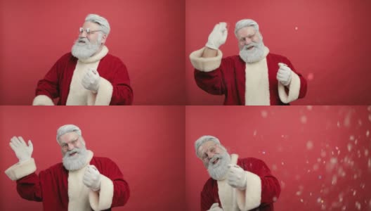滑稽快乐的圣诞老人把五彩纸屑吹向空中。欢喜,笑了。红色的背景高清在线视频素材下载