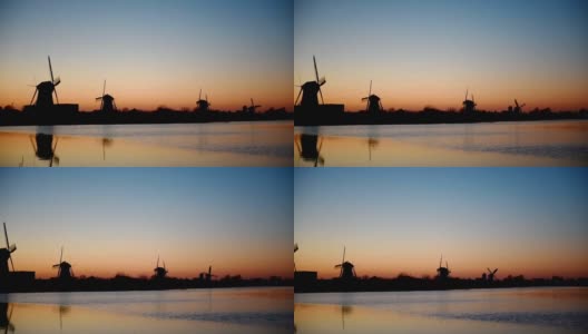 传统的荷兰风车在日落时从鹿特丹海峡。水镜的效果。荷兰高清在线视频素材下载