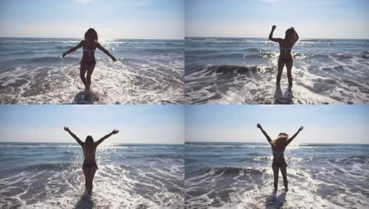 一名年轻女子走在海边，举手示意。一个无法辨认的美丽女孩在海边享受着生活和自由。暑假或假日概念。以自然景观为背景。慢镜头后视图高清在线视频素材下载