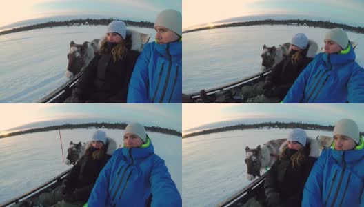 年轻的夫妇骑着驯鹿雪橇穿过白雪覆盖的拉普兰荒野高清在线视频素材下载