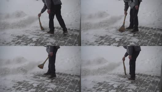 那个不知名的人清扫街上的积雪。缓慢的运动。高清在线视频素材下载