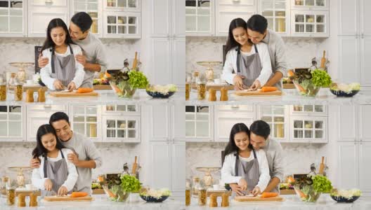 年轻的亚洲孕妇和丈夫在厨房做饭在家高清在线视频素材下载