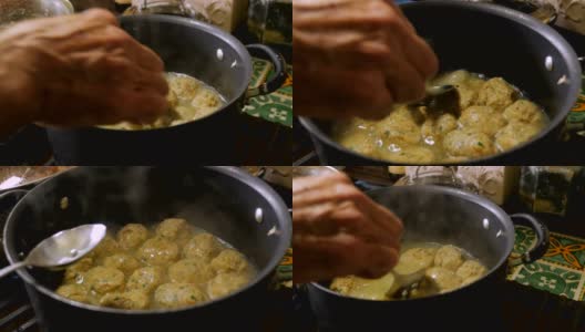 一个男人的手搅拌和烹饪无酵球汤在炉顶的特写高清在线视频素材下载