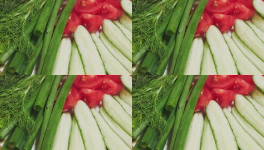 新鲜的蔬菜在桌子上旋转。生切片蔬菜，西红柿和黄瓜特写。素食。高清在线视频素材下载
