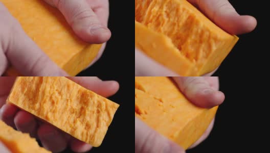 男人的手把切达干酪掰成两半。高清在线视频素材下载