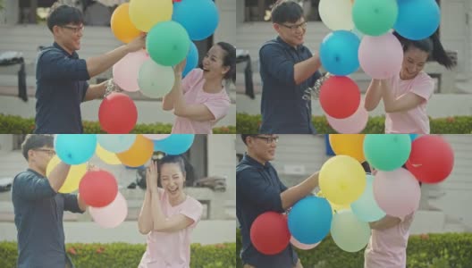 SLO MO亚洲夫妇拿着彩色气球高清在线视频素材下载