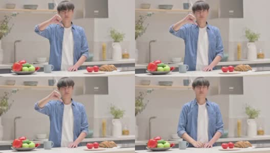 年轻亚洲男子在厨房里竖起大拇指高清在线视频素材下载