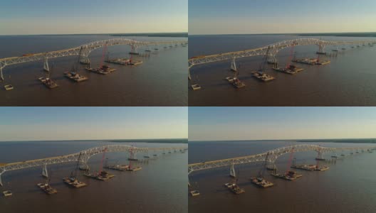 波托马克河重建鸟瞰图，靠近哈里·尼斯州长纪念馆/参议员托马斯·“麦克”·米德尔顿桥，连接弗吉尼亚州和马里兰州，水上有多艘浮吊船和建筑工地。高清在线视频素材下载