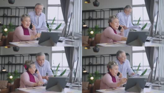 老的资深亚洲退休企业家在家里一起工作，在家隔离远程工作，用台式电脑和智能手机技术设备在家工作高清在线视频素材下载