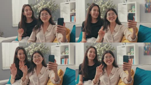 美丽的韩国，亚洲女性在新公寓的沙发上放松，室友，大学生，女士在她面前拿出电话视频通话，交谈，挥手问候，笑容灿烂高清在线视频素材下载