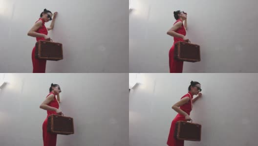 图为，在户外拍摄《时尚旗袍》时，背着行李戴着墨镜的中国年轻女子。高清在线视频素材下载
