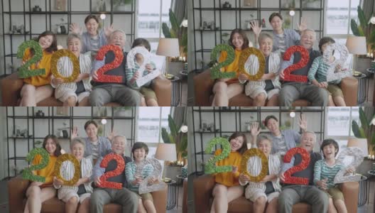 幸福亚洲多代2022年新年庆祝活动，亚洲家庭在客厅沙发上举行2022年文号与欢笑笑意欢畅的时刻，祖父母孙子父母坐在放松的沙发上高清在线视频素材下载