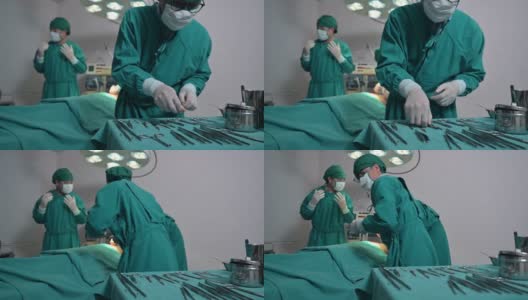 身穿手术服的外科医生团队正在选择手术设备，在手术室为受伤的病人进行手术高清在线视频素材下载