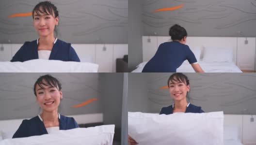 亚洲酒店的女服务员拿起枕头，看着镜头微笑。酒店员工以快乐的情感理念支持业务。高清在线视频素材下载