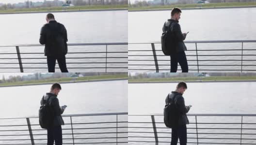 一个年轻人在城市的河边打电话高清在线视频素材下载
