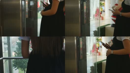 孕妇在电梯里使用智能手机高清在线视频素材下载