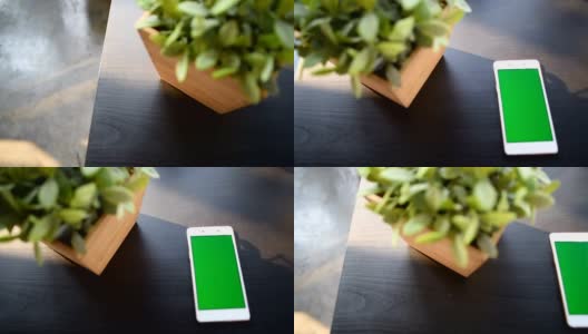 绿色屏幕的手机放在木桌上高清在线视频素材下载