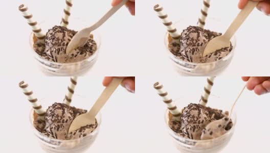 冰淇淋碗里的冰淇淋，上面装饰有威化饼卷。用木勺舀冰淇淋。高清在线视频素材下载