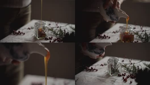 年轻女子把蜂蜜倒进一个罐子里做季节食谱高清在线视频素材下载
