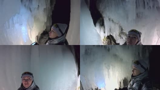 贝加尔湖冰洞上的女游客。观点认为有问题。女孩背包客正在冰洞中行走。游客看着美丽的冰洞。徒步旅行者穿银色夹克，背包，led灯。高清在线视频素材下载
