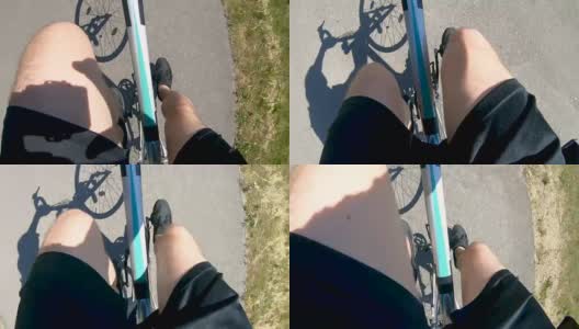 骑着自行车，在柏油路上投下阴影高清在线视频素材下载
