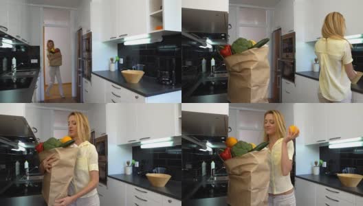 快乐的年轻女人带了一袋杂货到厨房高清在线视频素材下载