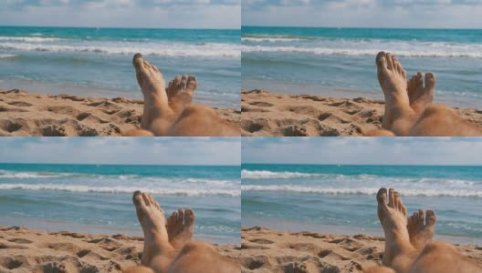 男人的腿躺在海边的沙滩上，POV。慢动作高清在线视频素材下载
