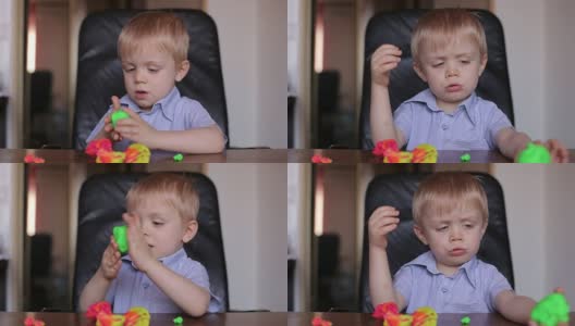 悲伤的小男孩玩彩色橡皮泥。高清在线视频素材下载