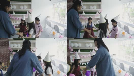 小男孩和小女孩在老师的聚会上玩气球高清在线视频素材下载