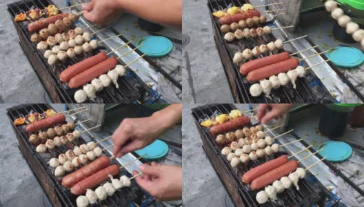 泰国街头小吃市场，摊贩的手在木炭炉上烤着肉丸、猪肉丸子和香肠。烹饪概念。视频片段。高清在线视频素材下载