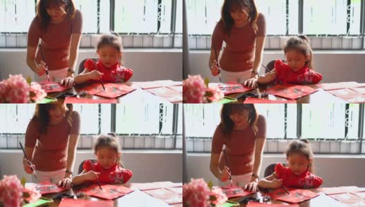 亚洲华人家庭在红纸上书写中国书法高清在线视频素材下载