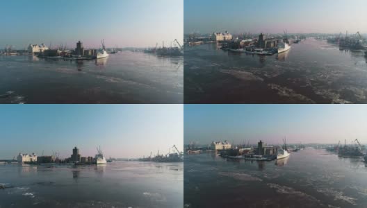 全景式的工业区周围的北港河上覆盖着冰，码头的起重机和商业船只高清在线视频素材下载