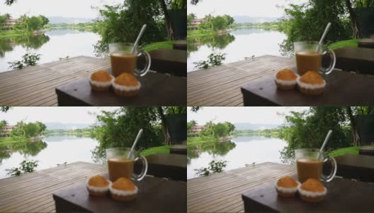 热咖啡和香蕉纸杯蛋糕，河背景高清在线视频素材下载