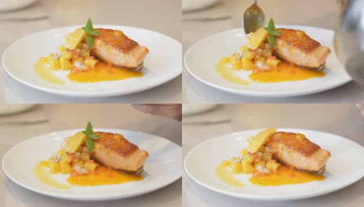 厨师用薄荷装饰橙汁煎鲑鱼高清在线视频素材下载