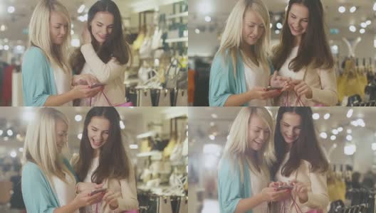 两个快乐的年轻女孩在一家百货商店里使用智能手机。高清在线视频素材下载