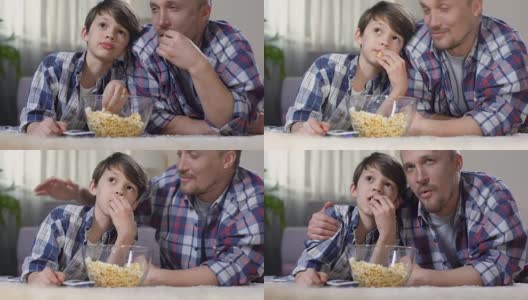 父亲抱着小儿子看电影，带着爆米花回家，为孩子感到骄傲高清在线视频素材下载
