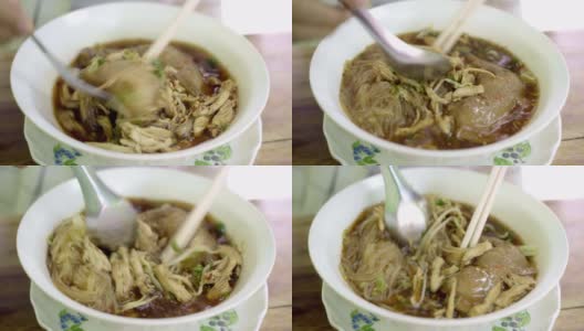 特写手用筷子夹吃泰国热面条。高清在线视频素材下载