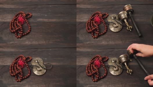 在棕色的木桌上放着一个带拍子的西藏唱歌铜碗，是用来冥想和替代医学的物品高清在线视频素材下载
