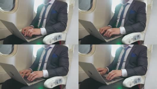 年轻的商人在飞机上使用笔记本电脑高清在线视频素材下载