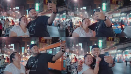 一对年轻夫妇正在享受街边小吃，并把照片发到社交媒体上高清在线视频素材下载