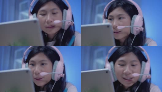 快乐的亚洲女孩使用耳机和麦克风通过数字平板电脑与她的老师和朋友交流，在COVID-19期间在家教育，社交距离概念。高清在线视频素材下载