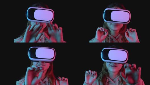 年轻女子在虚拟现实眼镜的特写。一个沉浸在虚拟现实中的女人用手做动作。蓝色和红色的光落在一个黑色背景上的女人身上。高清在线视频素材下载