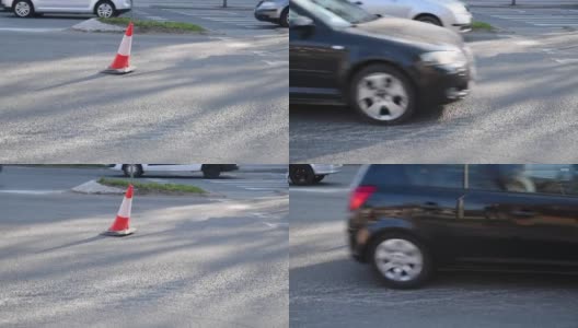 城市街道沥青路面上的交通锥警告司机由于道路施工和汽车通过的危险高清在线视频素材下载