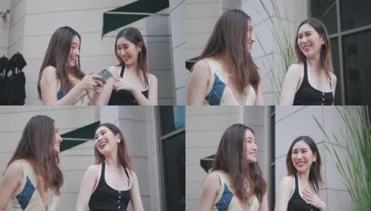快乐和微笑的亚洲两个女孩走在城市，享受他们的自由时间，有乐趣和聊天，而走在镇上高清在线视频素材下载