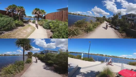 一个男孩在澳大利亚郊区湖边的人行道上骑着脚踏车。高清在线视频素材下载