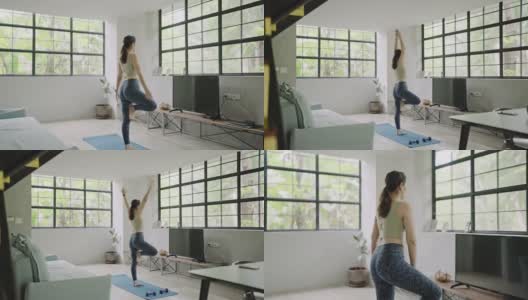 年轻女子在家里练习瑜伽高清在线视频素材下载