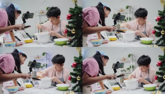 圣诞节期间，亚洲孩子们在家里拍摄饼干烹饪视频制作视频，或者在家里一起拍TikTok，这是新一代概念的时尚生活方式。高清在线视频素材下载