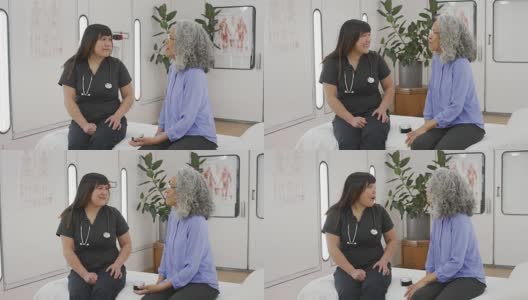 年轻的亚裔护士正在和她的老年病人谈话。高清在线视频素材下载