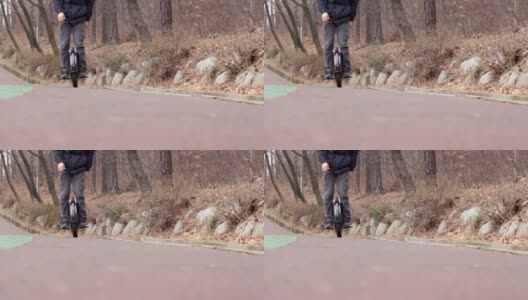 一个男人在城市公园里骑着电动独轮车，正面高清在线视频素材下载