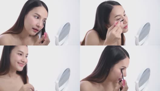 一位亚洲女性博主正在展示如何化妆和使用化妆品。在摄像机前录制视频直播流媒体在工作室高清在线视频素材下载